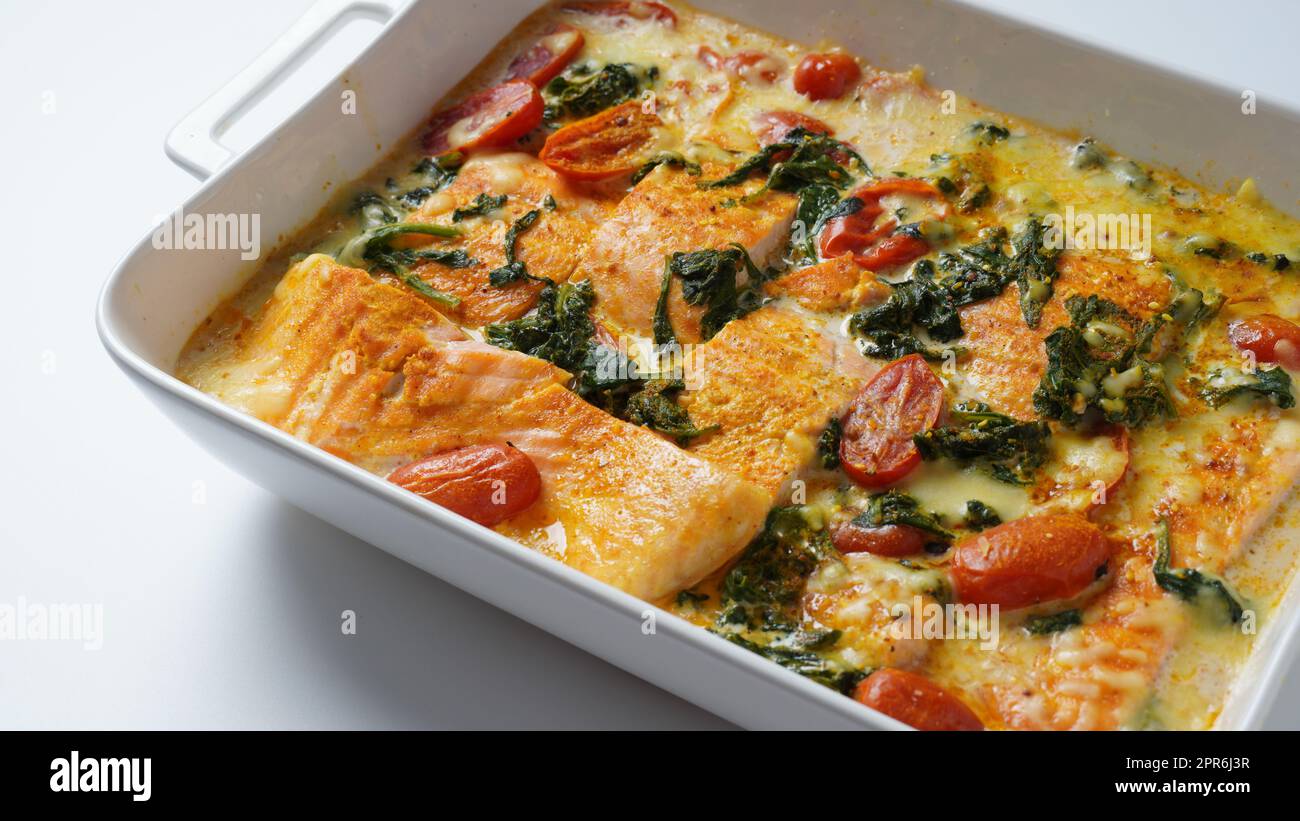 Lachsfilet mit Spinat und Kirschtomaten in cremiger Sauce Stockfoto