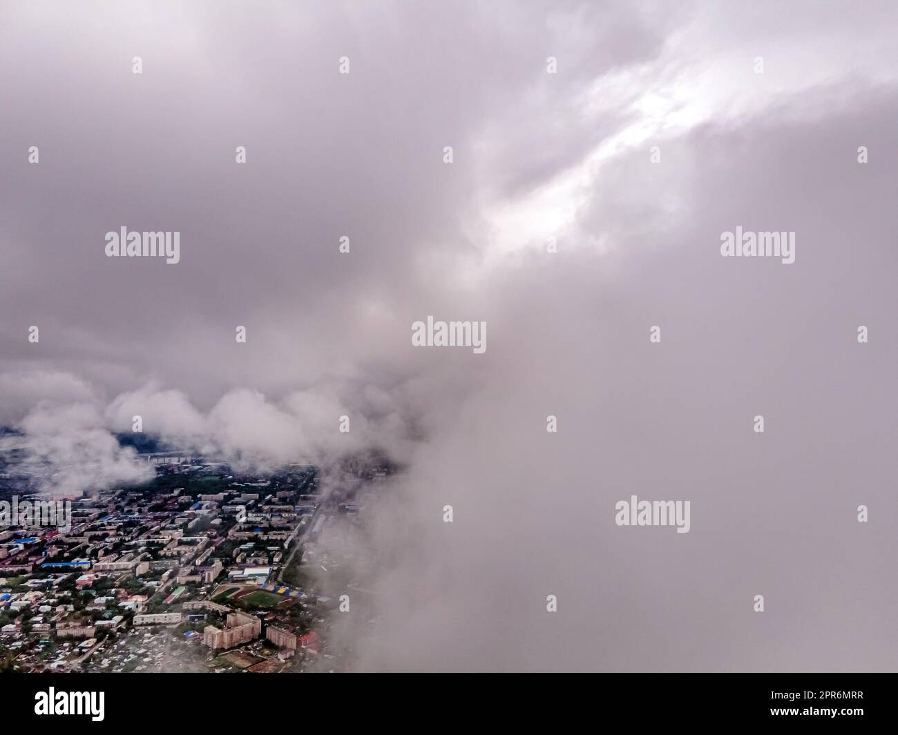Fliegen durch dicke Wolken. Regenwolken am Himmel. Kumuluswolken, Meteorologie und Klimastudien. Video der Stadt aus der Höhe der Wolken, Luftaufnahmen. Quadcopter, Drohne Stockfoto