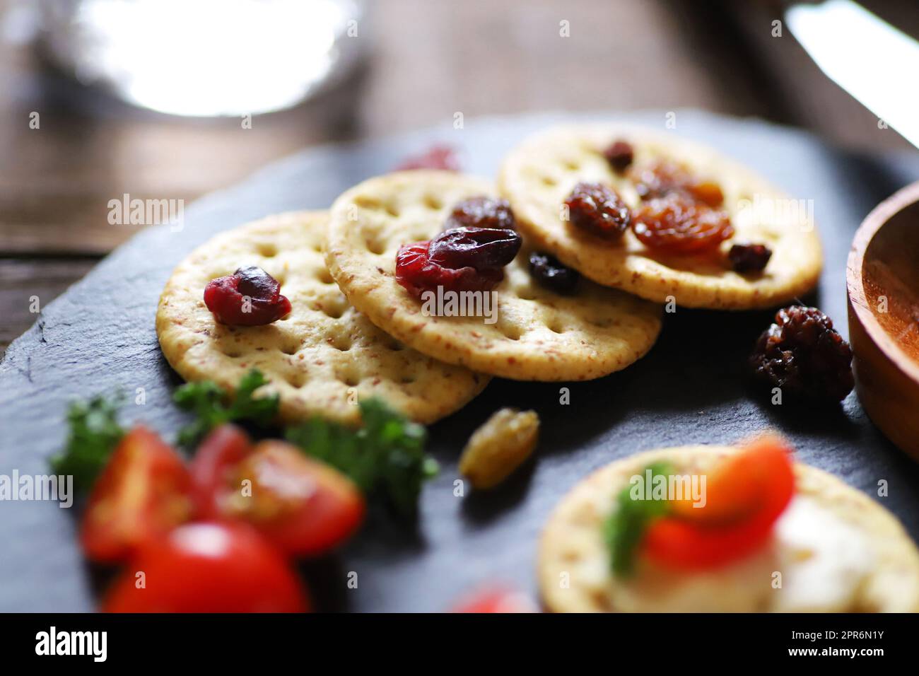 Vorspeisen und Snacks, Cracker, getrocknete Früchte, Tomaten und Petersilie Stockfoto