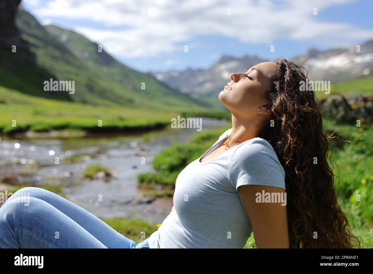 Lässige Frau, die frische Luft in den Bergen atmet Stockfoto