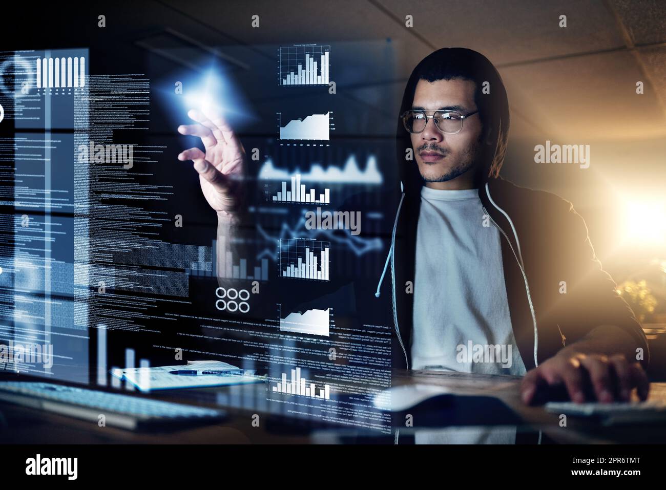 Hacker sind die Meister der Tarnung. Aufnahme eines jungen Hackers, der im Dunkeln einen Computercode knackt. Stockfoto