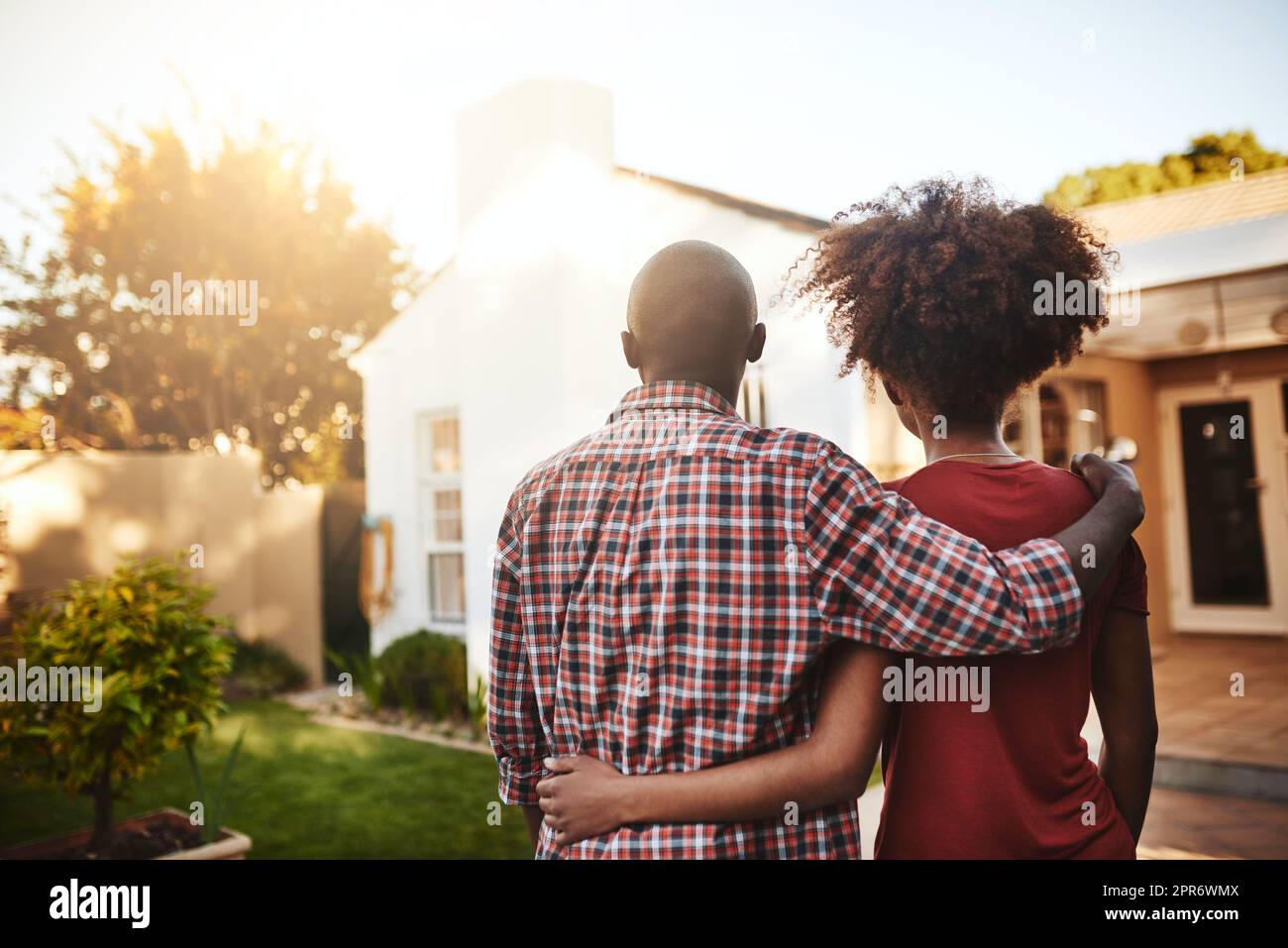 Was für ein schöner Ort, um unser Zuhause zu nennen. Rückansicht eines jungen Paares, das sein neues Haus draußen bewundert. Stockfoto