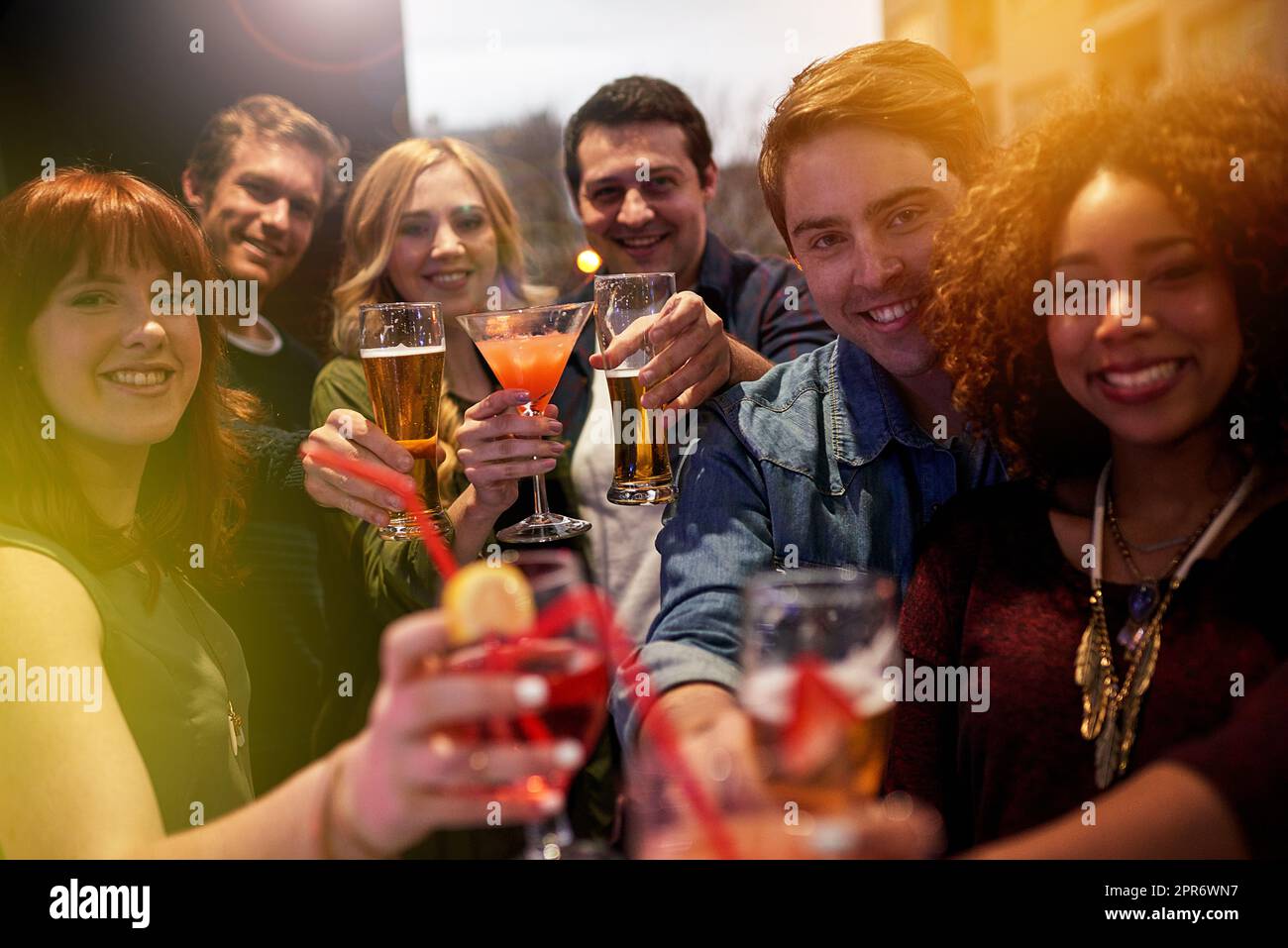 Lchaim. Porträt einer Gruppe von Menschen, die in einem Nachtclub mit ihren Getränken toasten. Stockfoto