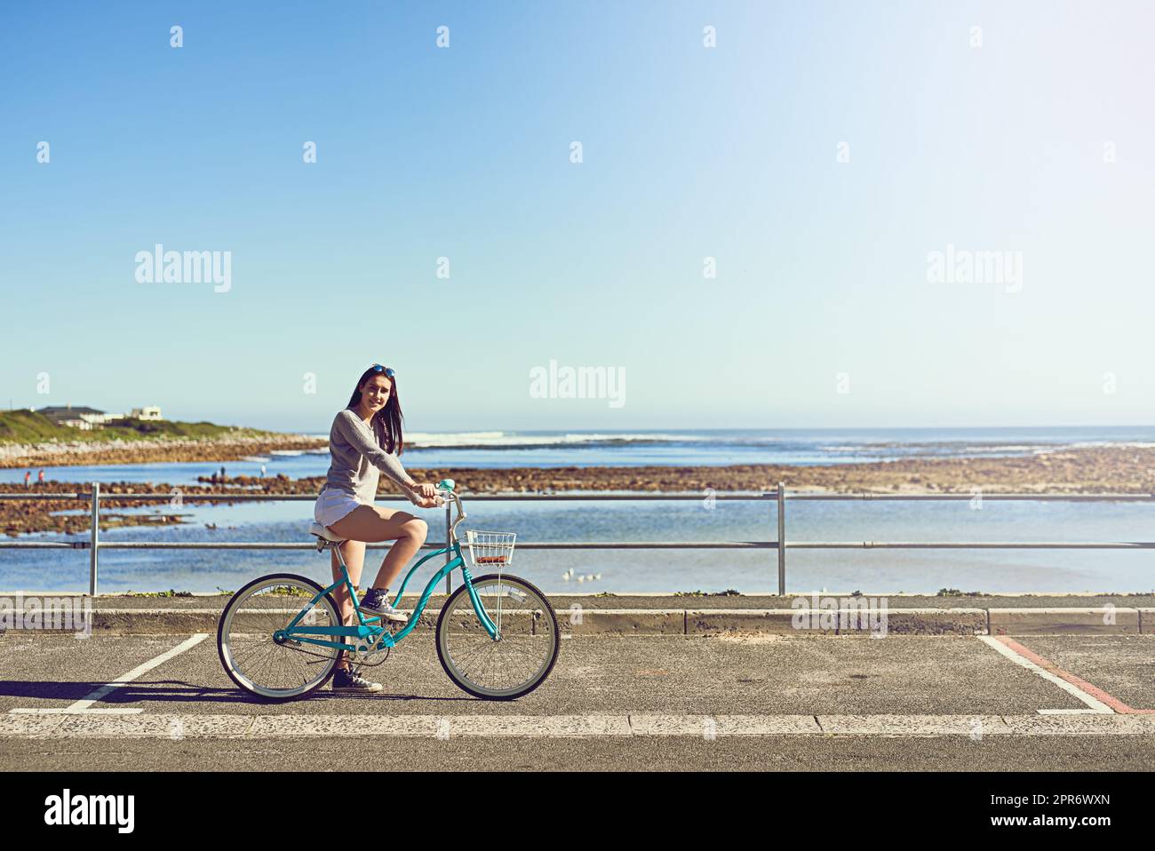 Mein Fahrrad, das Meer und ich. Porträt einer attraktiven jungen Frau, die draußen mit dem Fahrrad unterwegs ist. Stockfoto