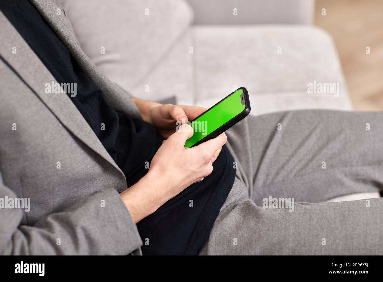 Männliche Hände schreiben zu Hause auf dem Telefonbildschirm. Stockfoto
