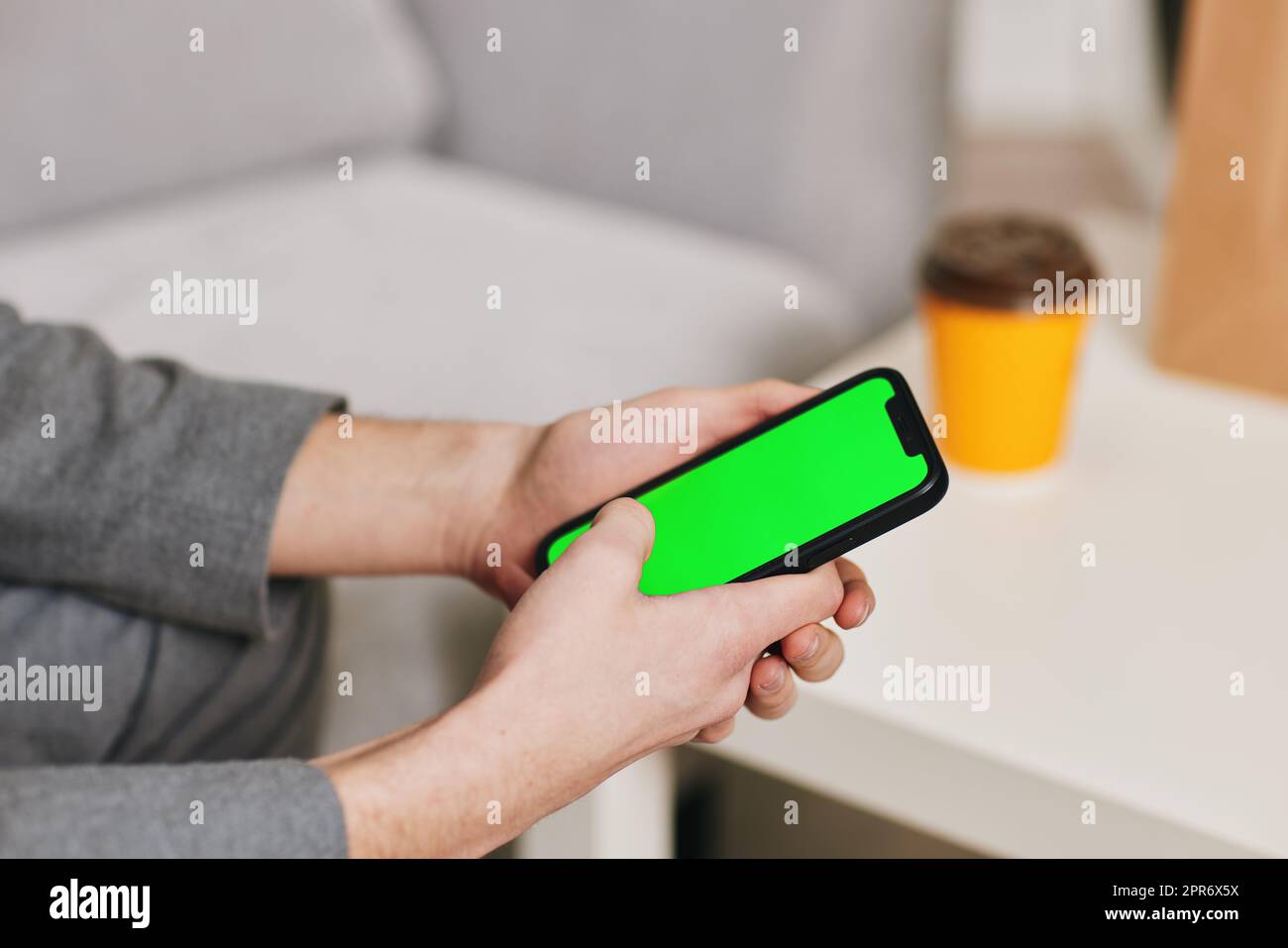 Männliche Hände schreiben zu Hause auf dem Telefonbildschirm. Stockfoto