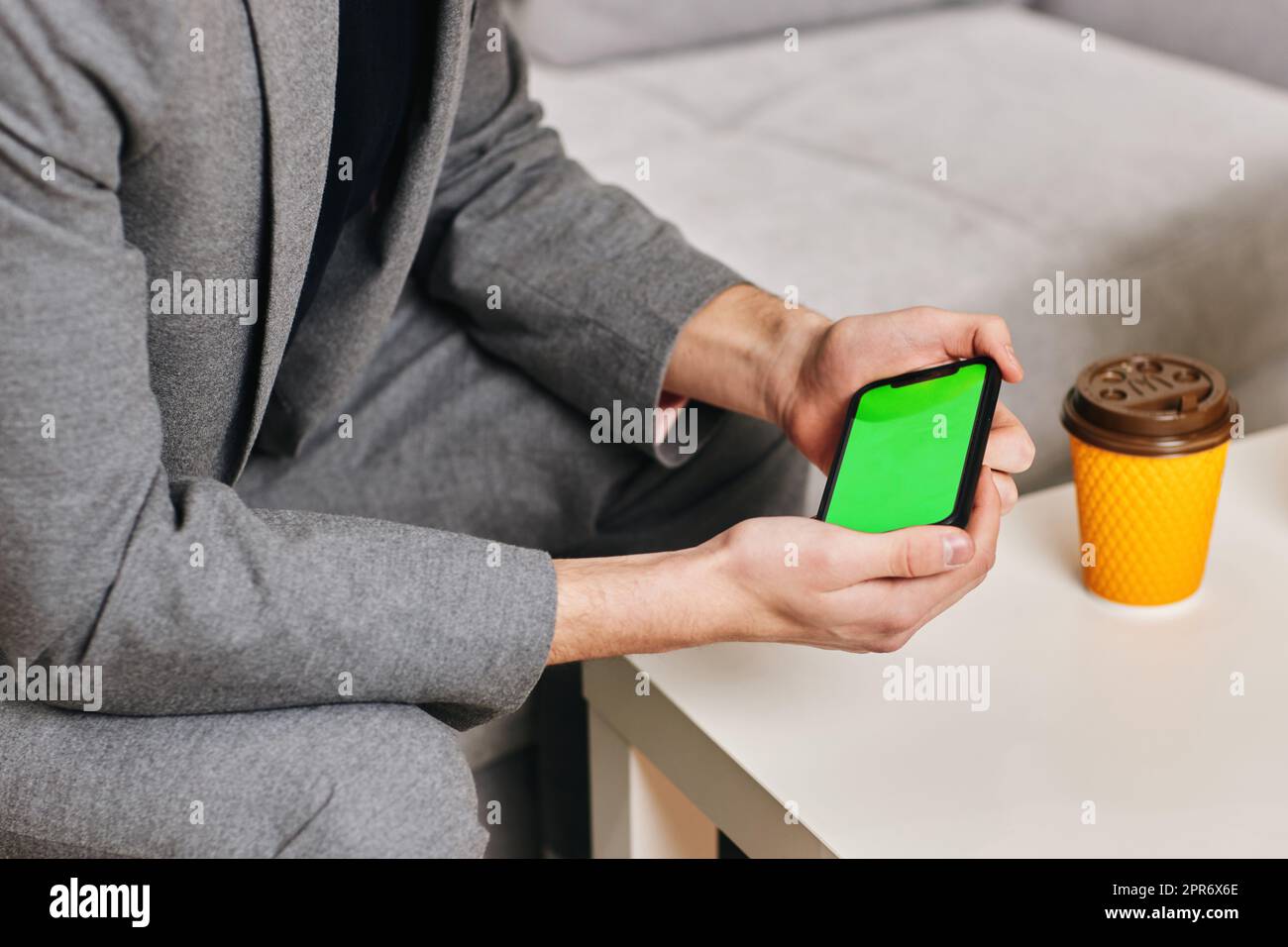 Männliche Hände schreiben zu Hause auf dem Telefonbildschirm. Stockfoto