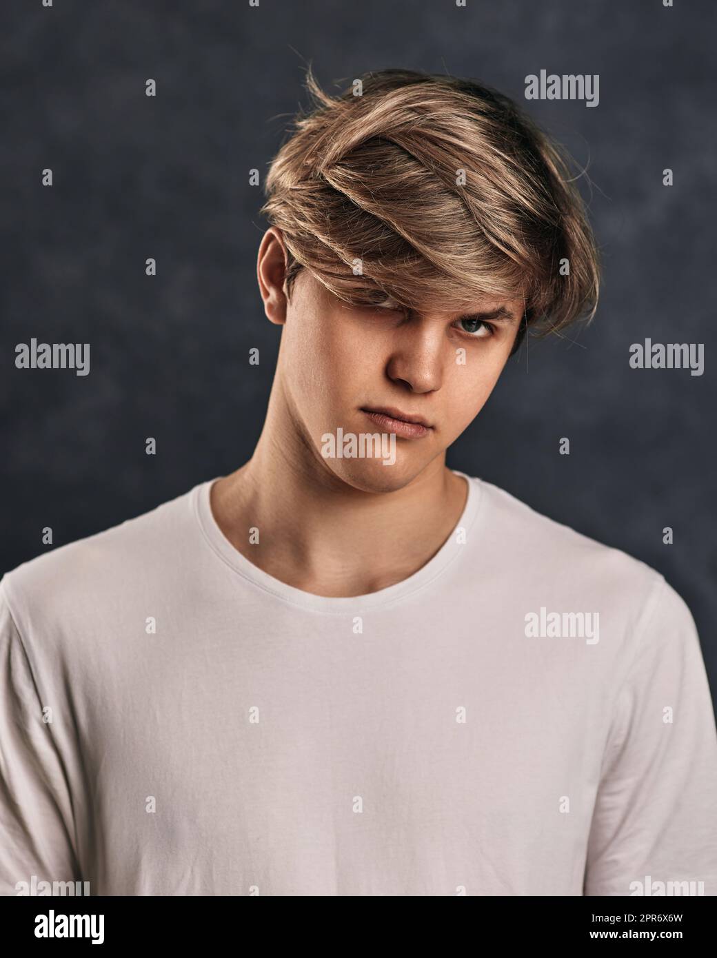 Verärgert junger Mann in T-Shirt auf grauem Hintergrund. Stockfoto