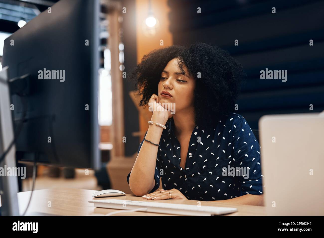 Ich begann, meinen Fokus zu verlieren. Aufnahme einer jungen, müde aussehenden Designerin, die tagsüber im Büro hinter ihrem Computer einschläft. Stockfoto