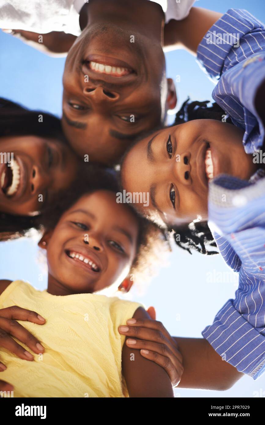 Die Köpfe zusammenfügen. Low-View-Porträt einer glücklichen afroamerikanischen Familie, die gemeinsam den Tag am Strand verbringt. Stockfoto