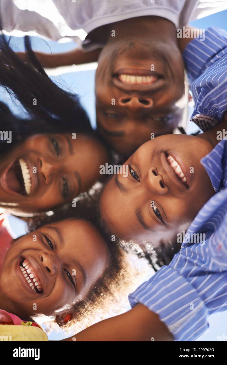 Familienzusammengehörigkeit. Low-View-Porträt einer glücklichen afroamerikanischen Familie, die gemeinsam den Tag am Strand verbringt. Stockfoto