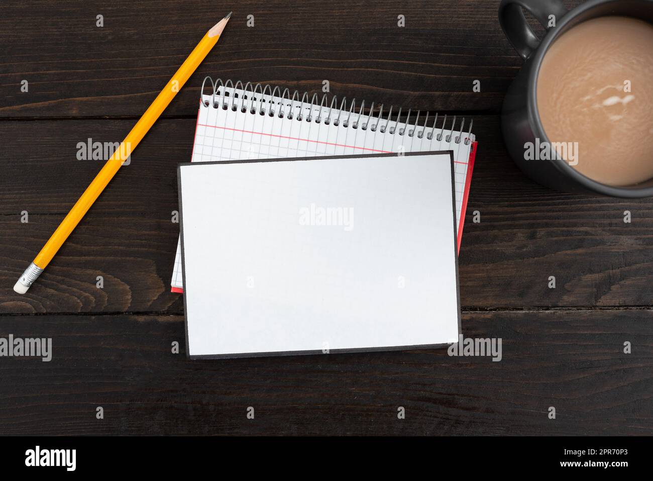 Leeres Papier Mit Spiralnotizbuch, Bleistift Und Kaffeebecher Auf Holzhintergrund. Leeres Blatt Mit Schreibwaren Und Getränk Auf Dem Tisch. Es Werden Wichtige Geschäftsinformationen Angezeigt. Stockfoto