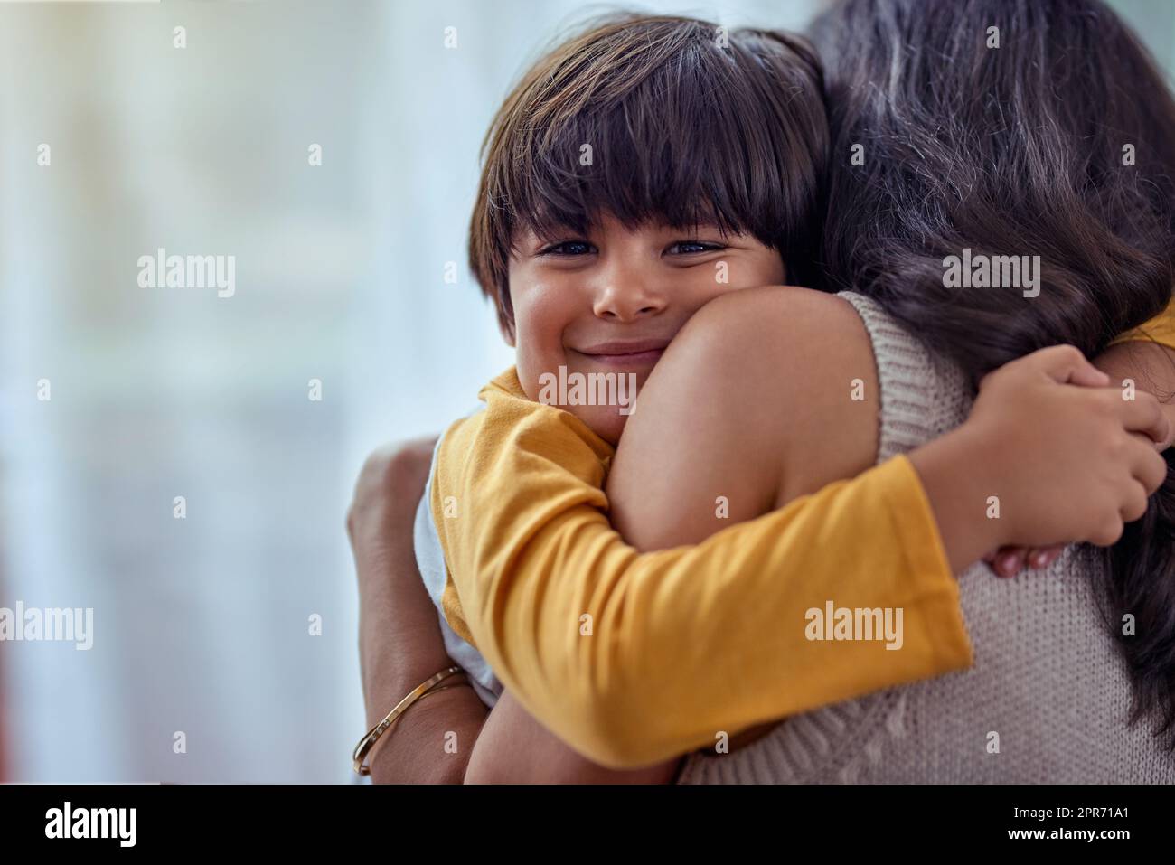 Die reinste Liebe von allen. Aufnahme eines entzückenden kleinen Jungen, der seine Mutter zu Hause liebevoll umarmt. Stockfoto