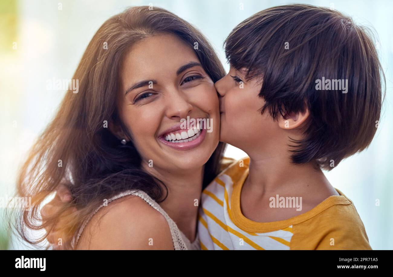 Es gibt etwas Besonderes an der Mutter Sohn Verbindung. Aufnahme eines entzückenden kleinen Jungen, der seine Mutter zu Hause liebevoll küsst. Stockfoto
