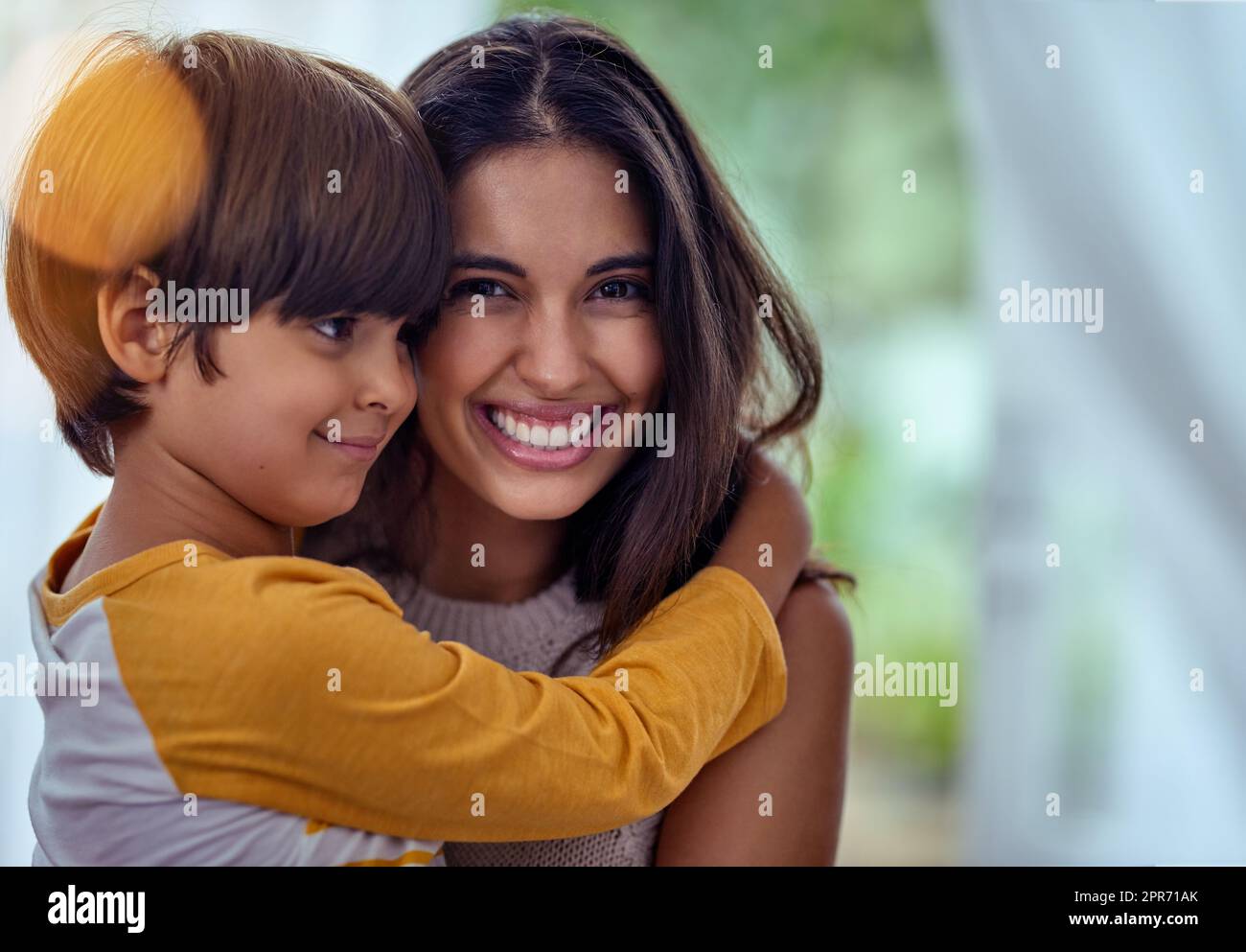 Mütter lieben, das Fundament, auf dem sich glückliche Kindheiten bilden. Aufnahme eines entzückenden kleinen Jungen, der seine Mutter zu Hause liebevoll umarmt. Stockfoto
