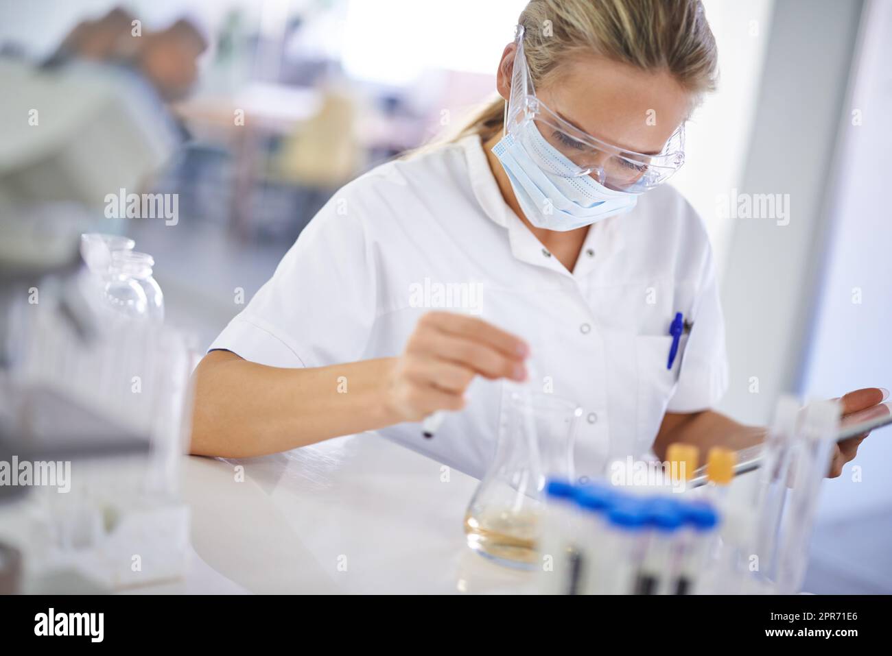 Testen einer Theorie. Eine junge Wissenschaftlerin, die in ihrem Labor ein Experiment durchführt. Stockfoto