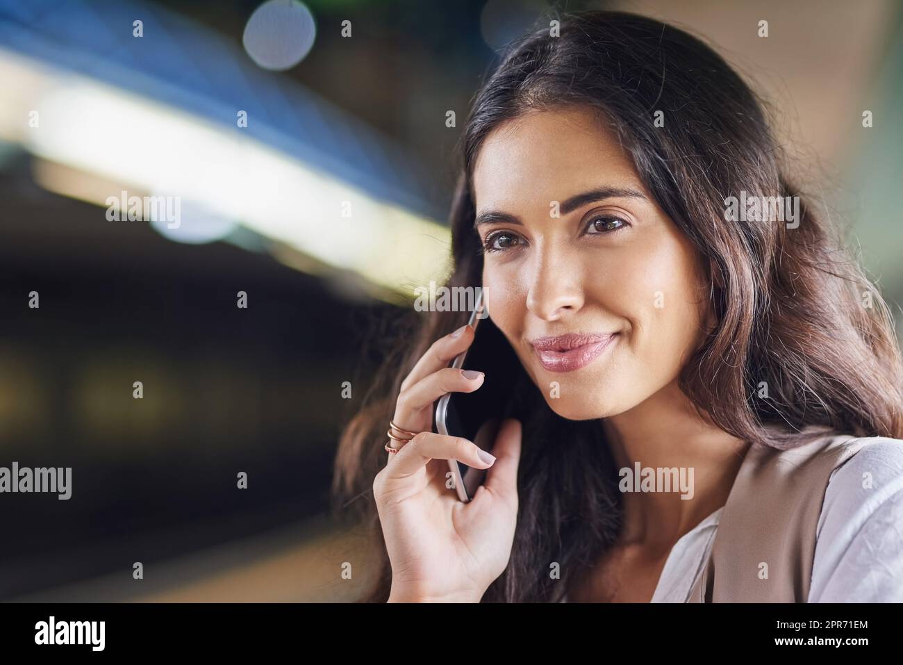 Hören Sie gute Nachrichten während der Fahrt. Ausgeschnittene Aufnahme einer jungen attraktiven Frau, die auf einem Anruf und mit dem Zug pendelte. Stockfoto