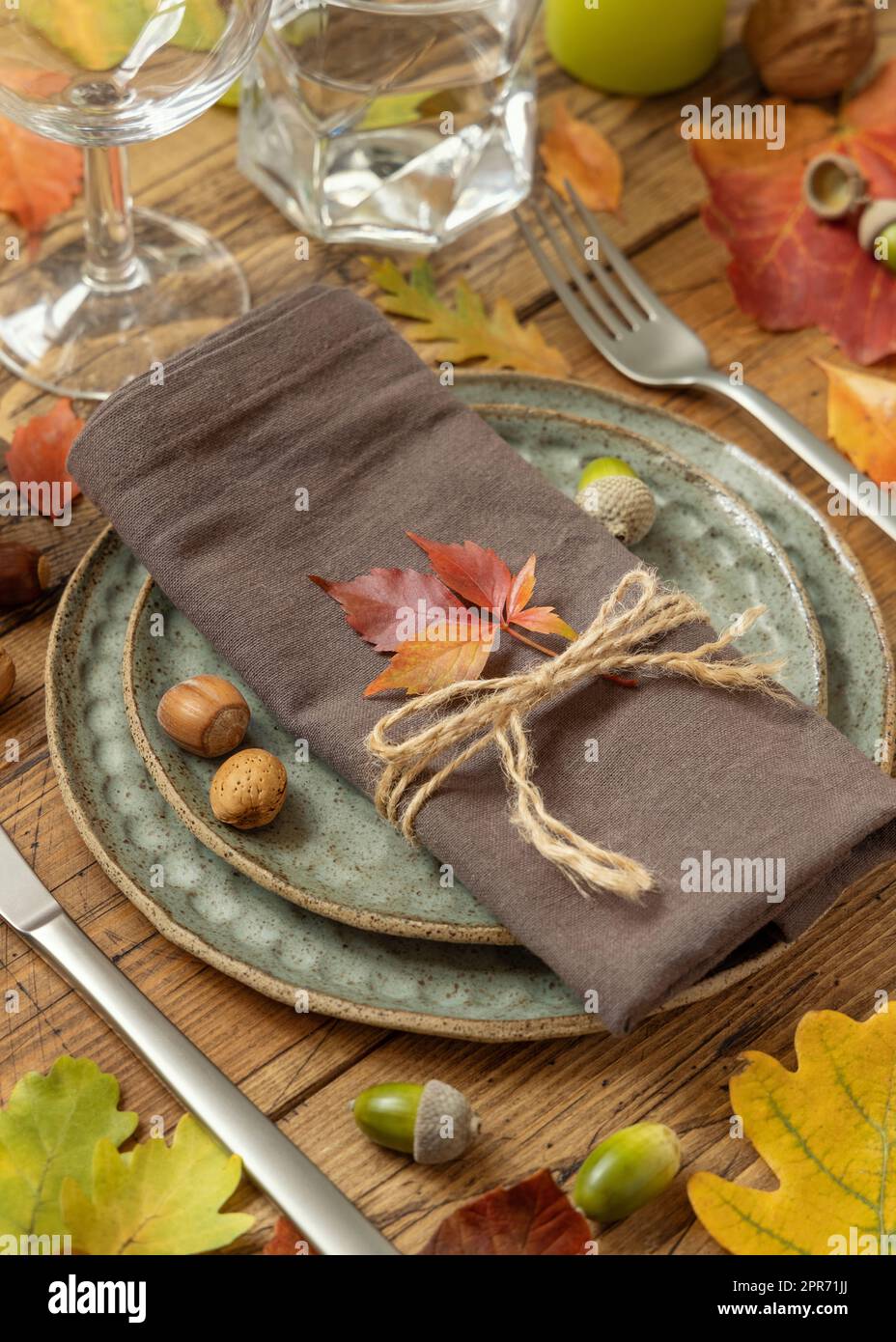 Rustikale Tischgestaltung im Herbst zwischen Blättern und Beeren auf altem Holztisch Stockfoto