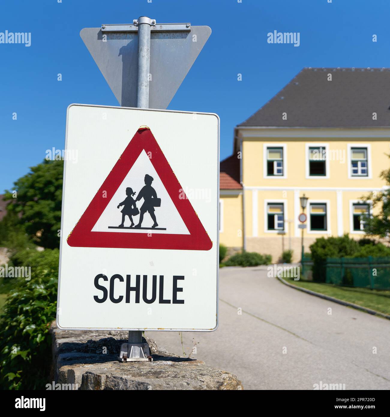Warnschild mit Hinweis auf mögliche Schulkinder im Straßengebiet der Gemeinde Emmersdorf in Österreich. Übersetzung auf dem Schild: Schule Stockfoto