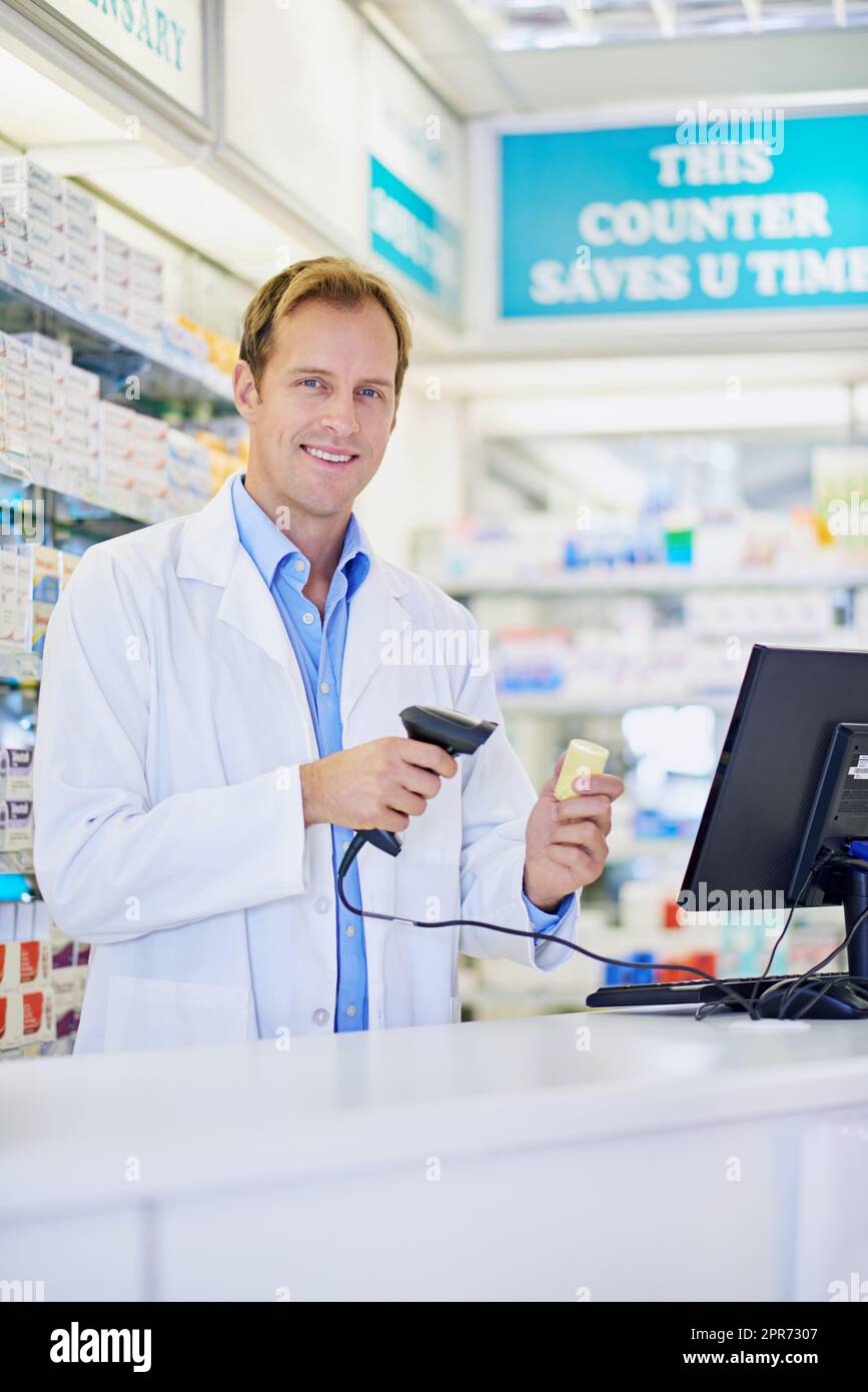 Technologie macht alles einfacher. Ein Apotheker scannt den Preis auf einer Flasche Pillen. Stockfoto
