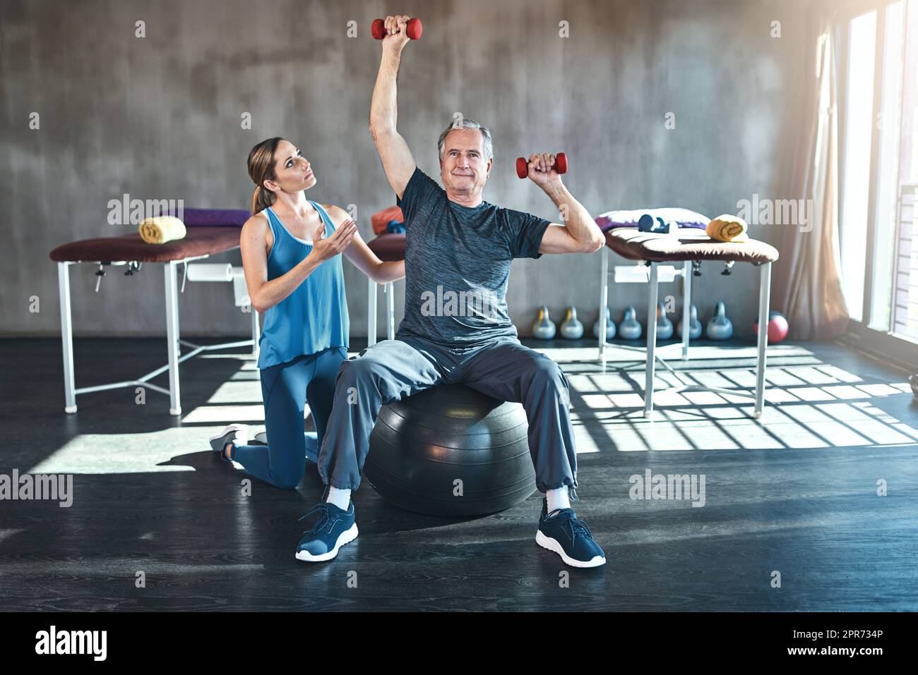Den Krieg gegen Muskelschwäche gewinnen. Aufnahme eines älteren Mannes, der mit seinem Physiotherapeuten arbeitet. Stockfoto