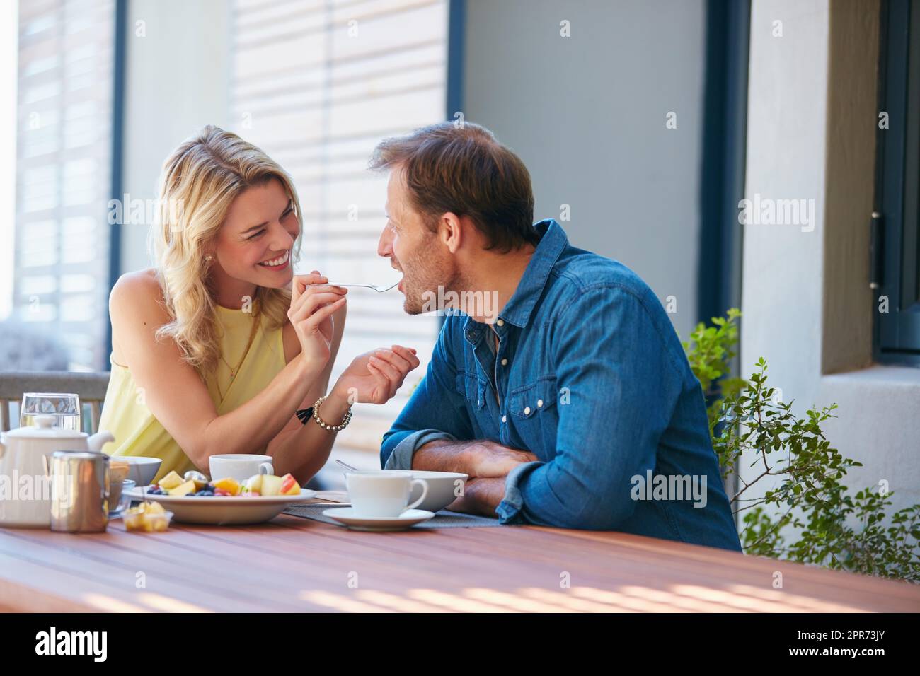 Schreckt Ihr mich auf? Aufnahme einer glücklichen jungen Frau, die ihrem Mann einen Vorgeschmack auf ihr Essen gab. Stockfoto