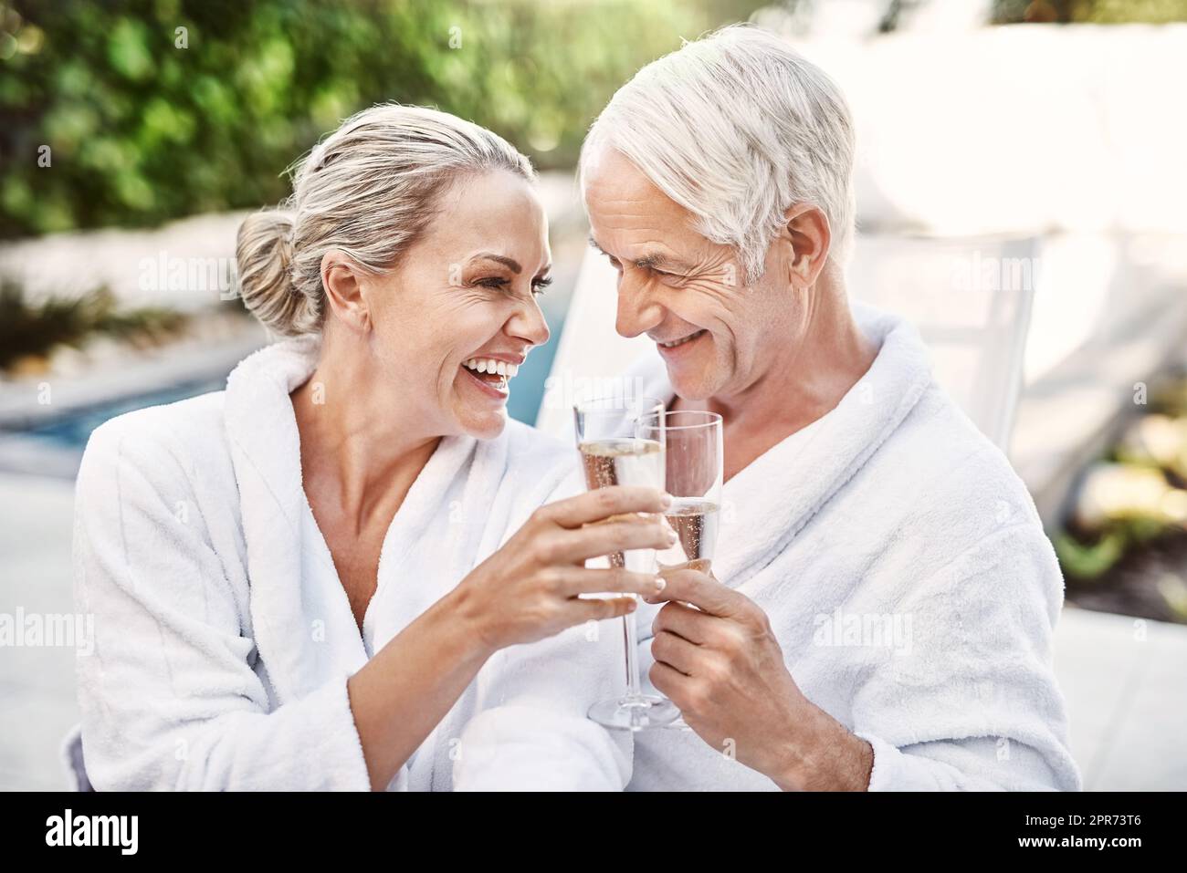 Ich liebe solche Momente mit dir. Aufnahme eines fröhlichen Paares mittleren Alters, das tagsüber draußen einen festlichen Toast mit Champagner gab. Stockfoto