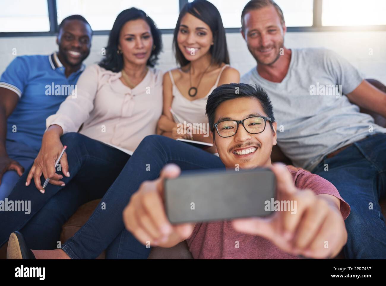 Es ist immer Zeit für ein Selfie am Arbeitstag. Aufnahme einer fröhlichen Gruppe kreativer Kollegen, die gemeinsam im Büro für ein Selfie posieren. Stockfoto