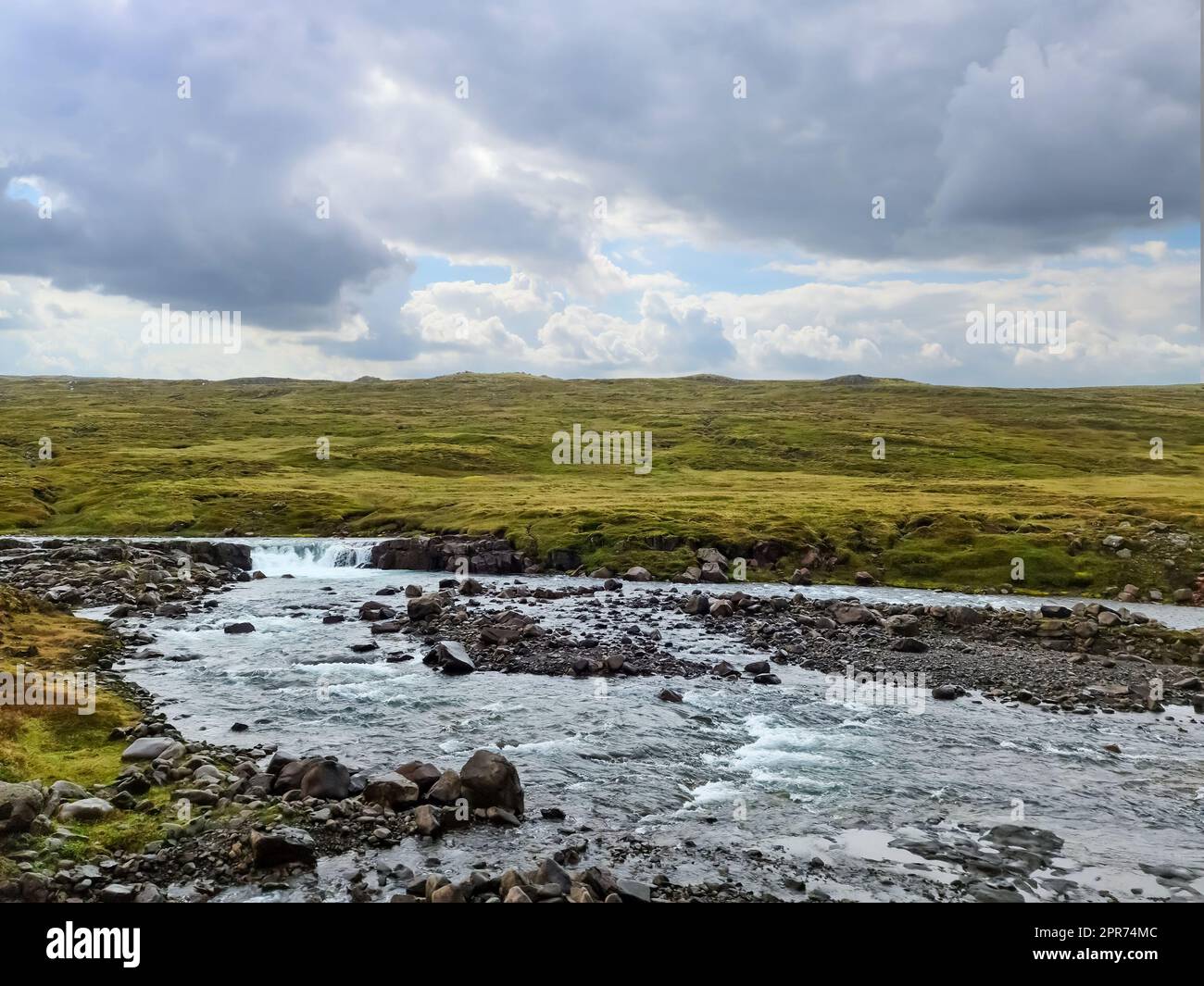 Fantastische Landschaft mit fließenden Flüssen und Bächen mit Felsen und Gras in Island. Stockfoto