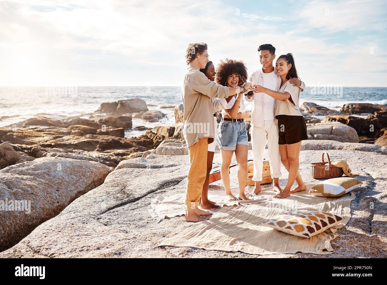 Eine Gruppe von Freunden genießt ihre Zeit zusammen und feiert mit einigen alkoholischen Getränken am Strand Stockfoto