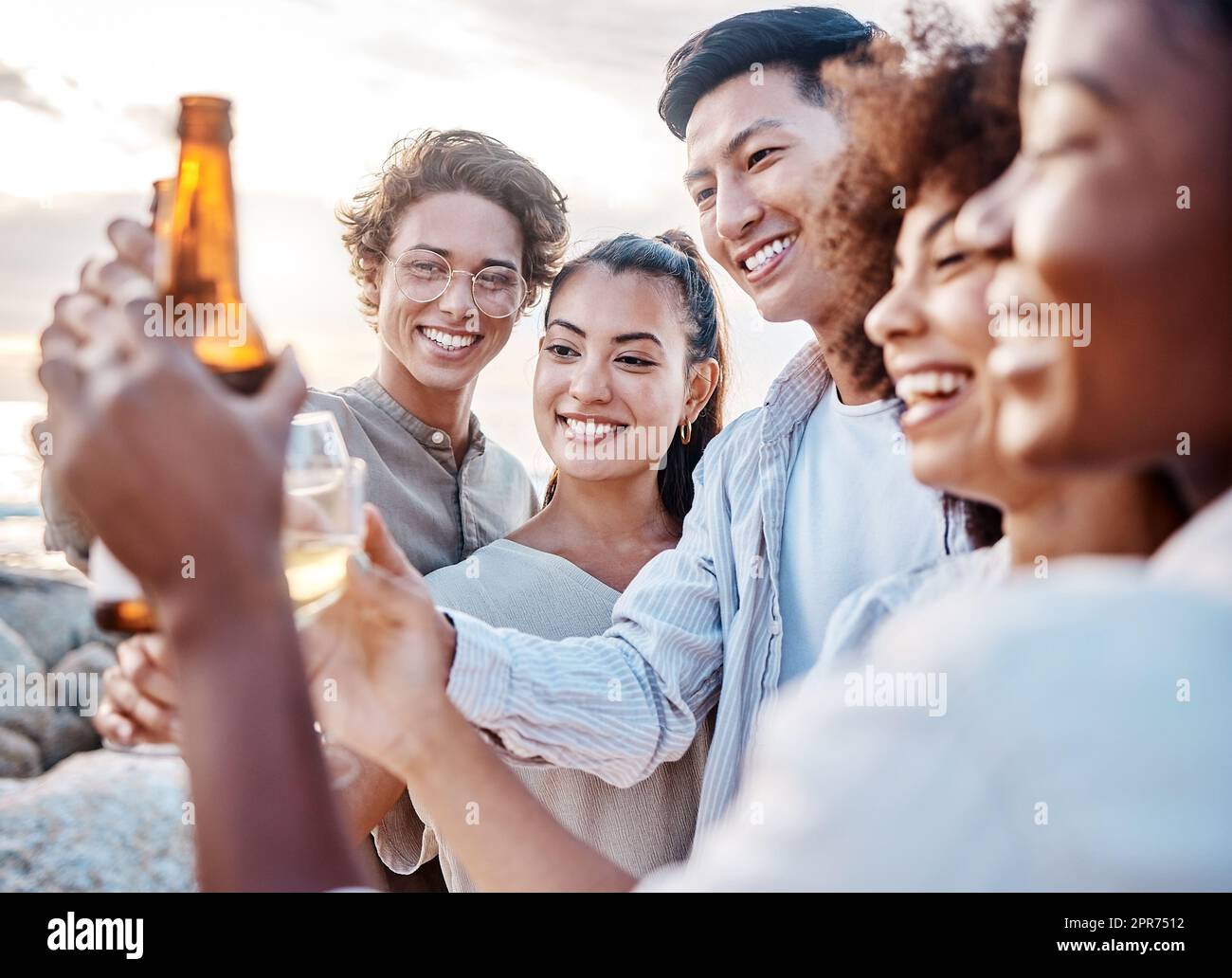 Eine Gruppe von Freunden genießt ihre Zeit zusammen und feiert mit einigen alkoholischen Getränken am Strand Stockfoto