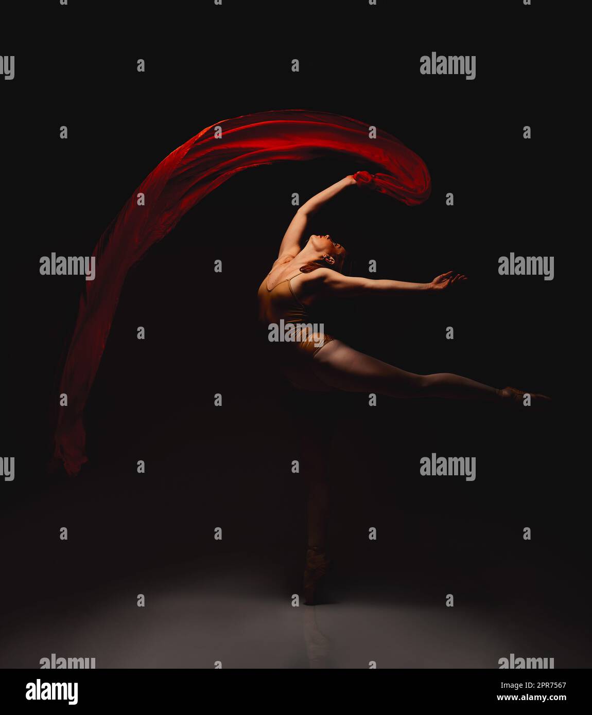 Sie lebt für die Kunst. Aufnahme einer Performerin, die vor dunklem Hintergrund tanzt. Stockfoto