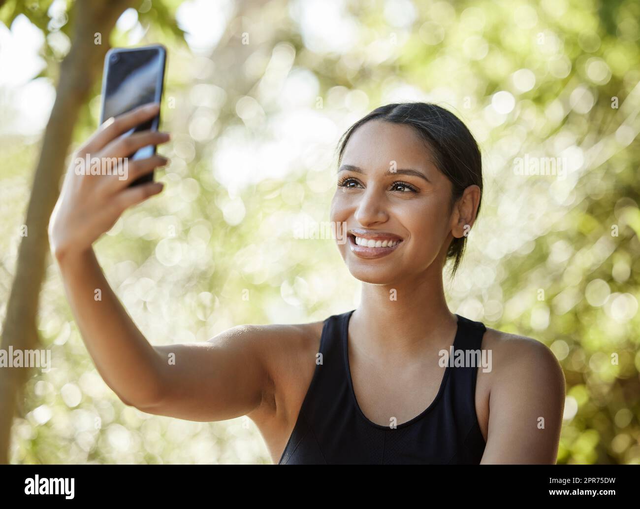 Selfies während des Trainings. Eine kurze Aufnahme einer attraktiven jungen Sportlerin, die beim Training im Freien Selfies macht. Stockfoto