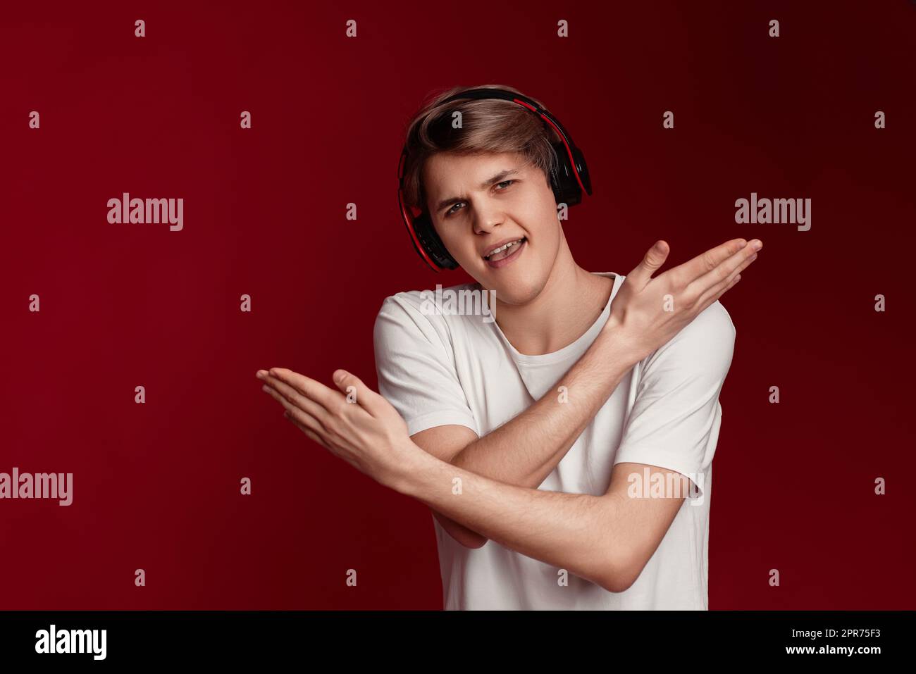 Mann im lässigen weißen T-Shirt mit modernen Kopfhörern Stockfoto