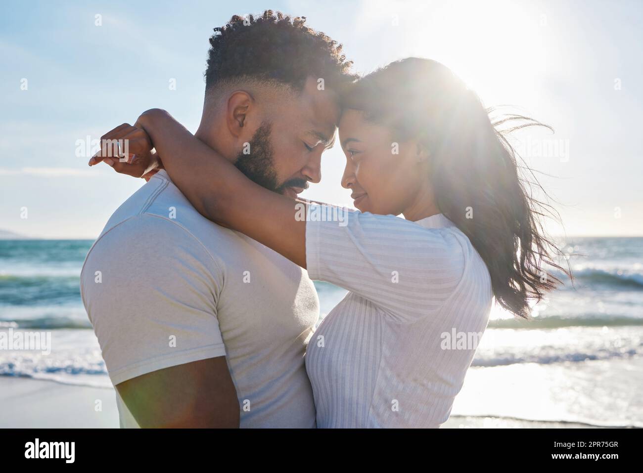 Junge Liebe. Eine kurze Aufnahme eines liebevollen jungen Paares, das einen intimen Moment am Strand teilt. Stockfoto