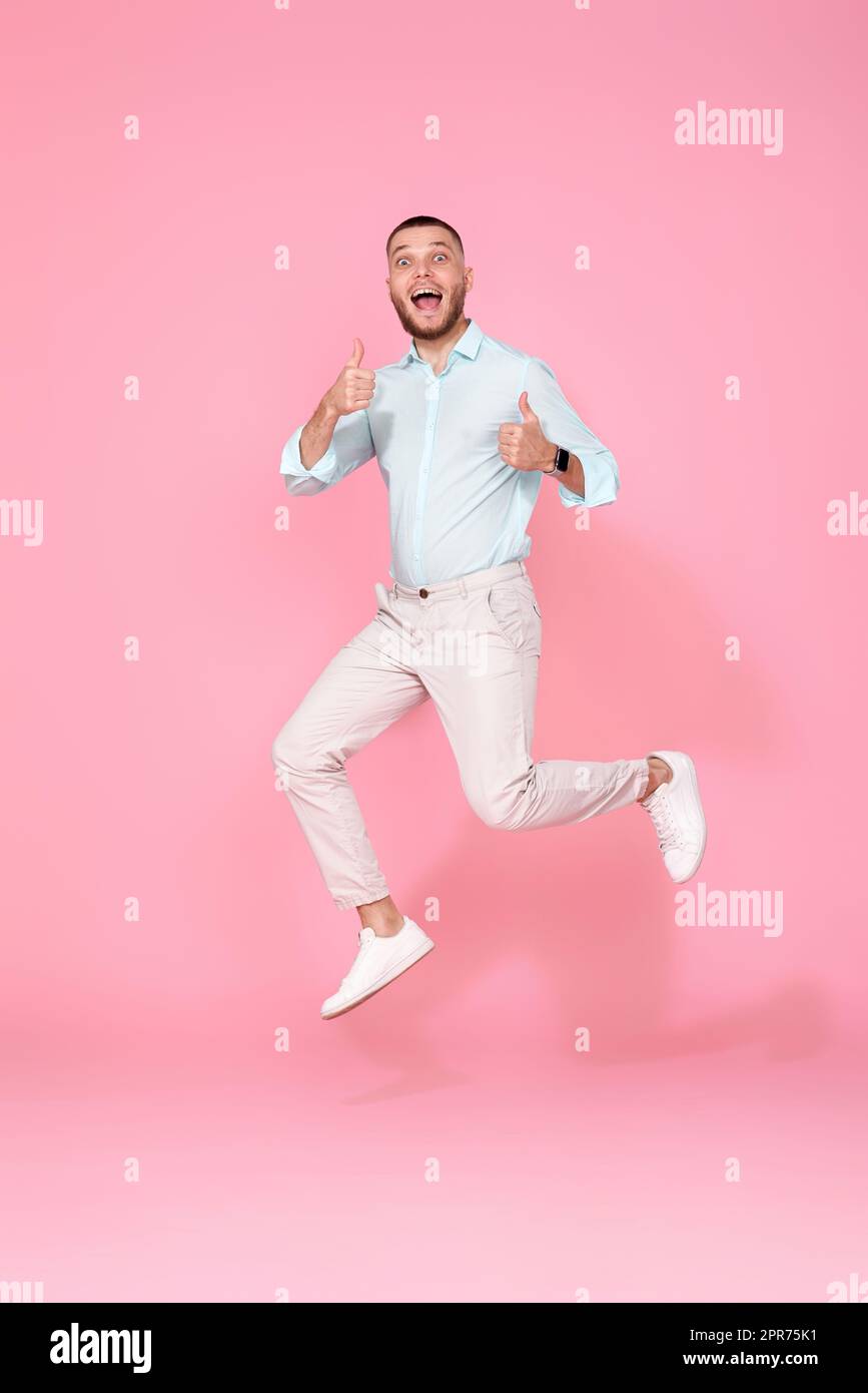 Mann in Sommerkleidung springt auf rosa Hintergrund. Stockfoto