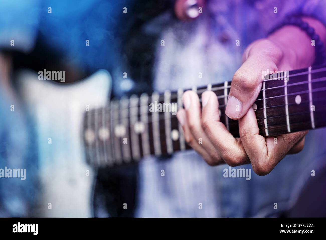 Bühnenpräsenz ist alles. Nahaufnahme eines nicht erkennbaren männlichen Gitarristen, der auf der Bühne auftrat. Stockfoto