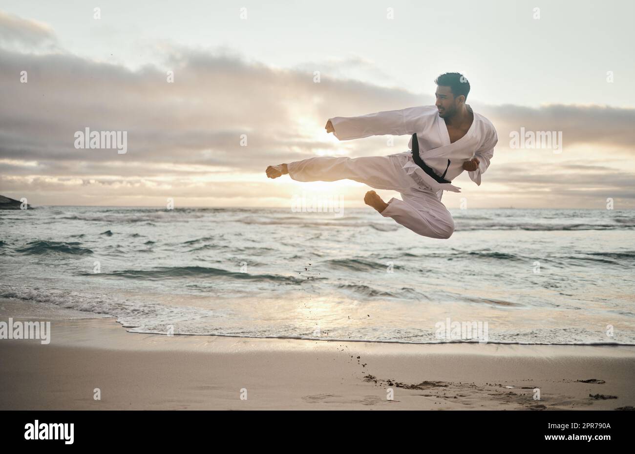 Ruhe bewahren und loslegen. Aufnahme eines jungen Kampfkünstlers, der am Strand Karate übt. Stockfoto