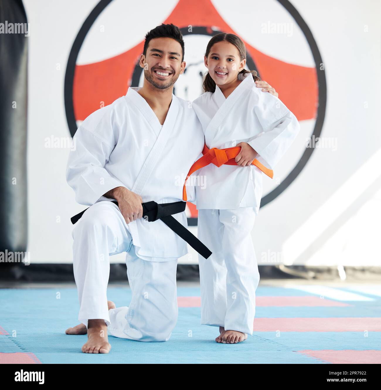 Egal wie klein, immer hoch stehen. Aufnahme eines jungen Mannes und eines niedlichen kleinen Mädchens, das in einem Studio Karate praktiziert. Stockfoto