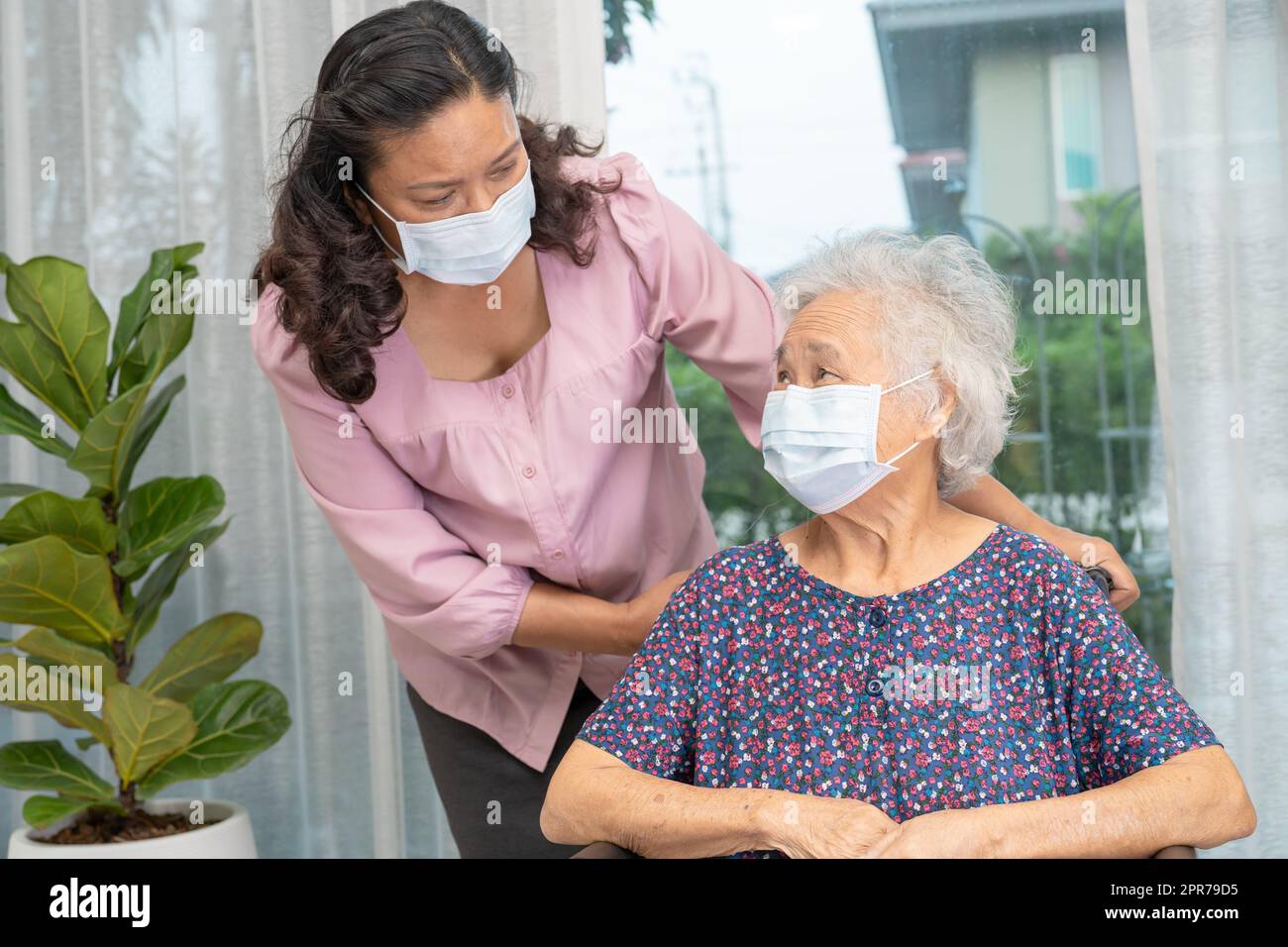 Pfleger Hilfe asiatische ältere oder ältere alte Dame Frau auf Rollstuhl sitzen und tragen eine Gesichtsmaske zum Schutz der Sicherheitsinfektion Covid19 Coronavirus. Stockfoto