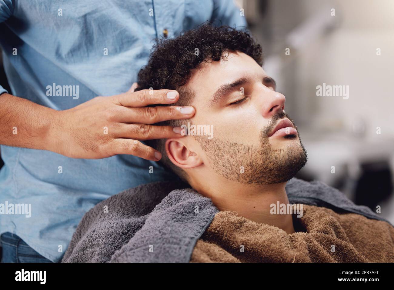 Nichts entspannender als der Barbier. Ein hübscher junger Mann, der von einem Barbier gepflegt wird. Stockfoto