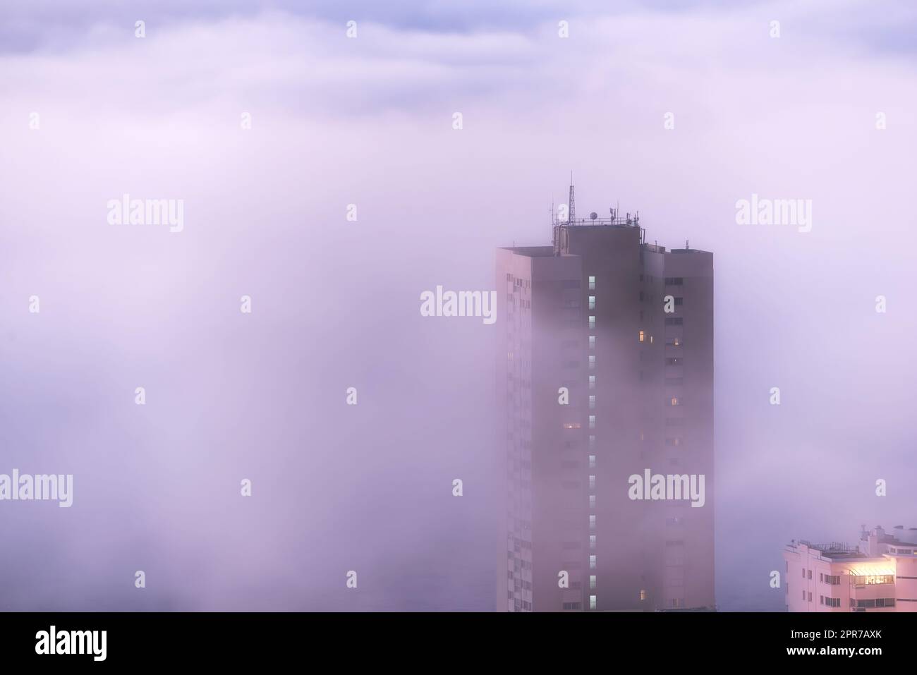 Luftaufnahme von Nebel oder Nebel über dem Stadtgebäude und dem Wolkenkratzer in der Innenstadt am frühen Morgen mit Kopierraum. Kaltwetterfront, Lauffeuer oder Buschbrand Rauch rollt in die Stadt in Südafrika Stockfoto