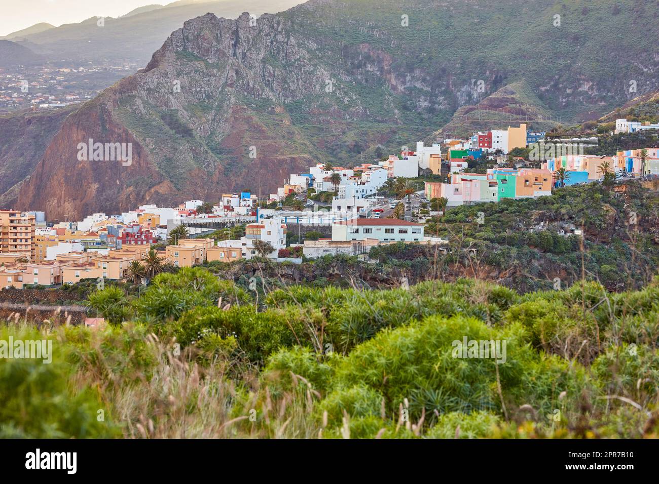 Farbenfrohe Gebäude in Santa Cruz, La Palma, Kanarische Inseln mit Kopierbereich. Wunderschöne Stadtlandschaft mit hellen Farben und Bergen. Ein pulsierender Urlaub, Urlaub und Kurzurlaub auf dem Hügel Stockfoto