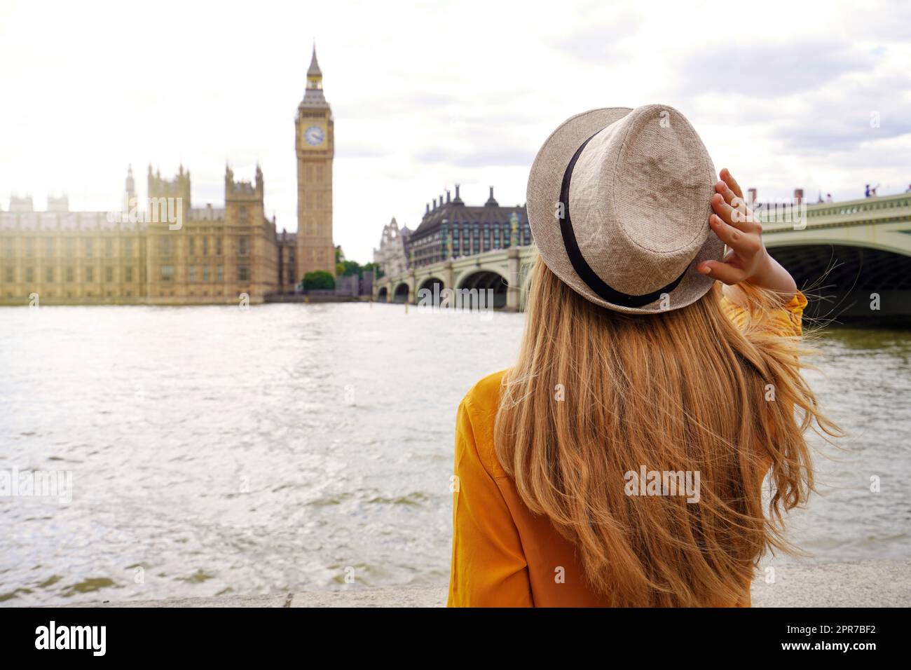 Tourismus in London. Rückansicht einer Touristenfrau, die den Westminster Palast und die Brücke auf der Themse mit dem berühmten Big Ben Turm in London, Großbritannien, bewundern kann. Stockfoto