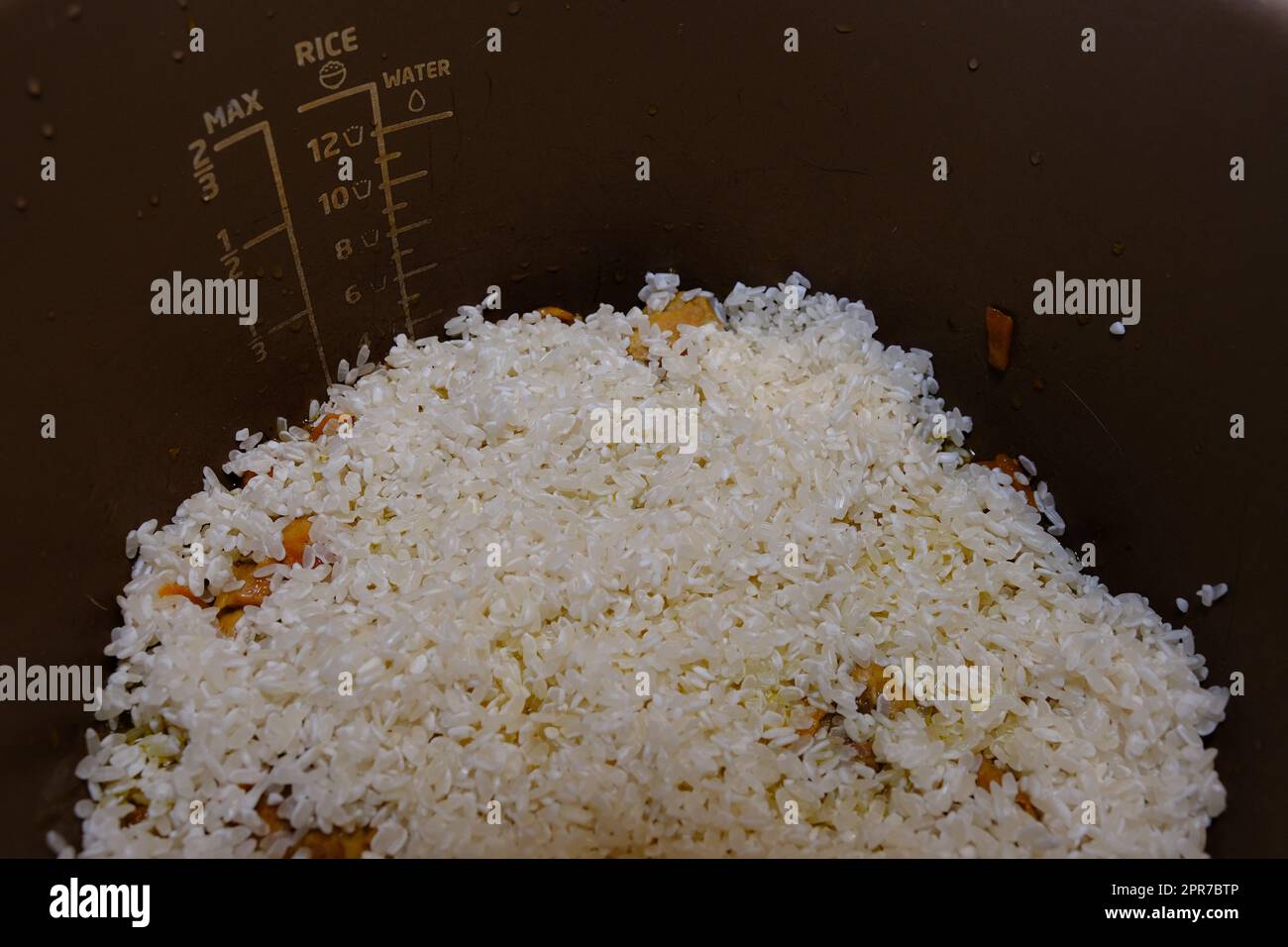 Schrittweises Kochen von Reis mit Fleisch und Gemüse im Schnellkocher. Gib Reis hinzu, Pilaff Stockfoto