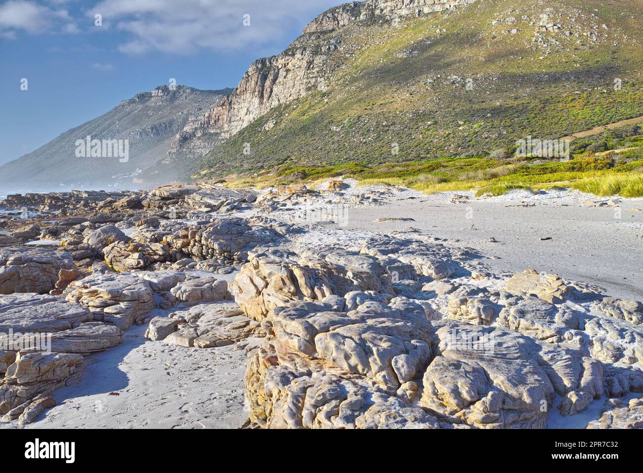 Landschaft mit Felsen und Bergen am felsigen Strand in Kapstadt, Südafrika. Leerer Strand an einem Sommertag an einem Wochenende draußen mit Kopierraum. Genießen Sie Urlaub und Urlaub im Übersee- und Ausland Stockfoto