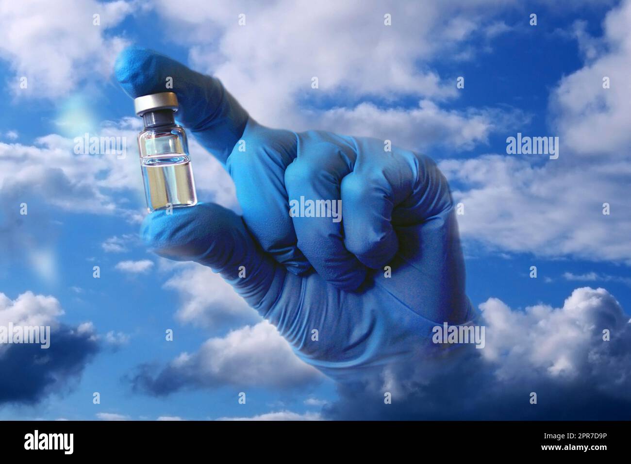 Eine Hand in einem blauen medizinischen Handschuh ragt aus den Wolken und hält ein Fläschchen Impfstoff. Collage. Stockfoto