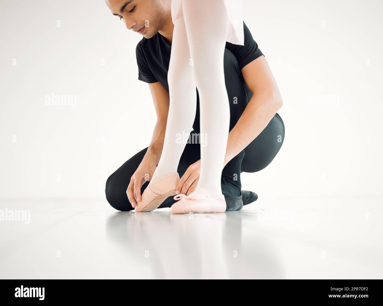 Positionieren Sie Ihre Füße so. Nahaufnahme einer Ballettlehrerin, die einer Schülerin bei ihrer Position in einem Tanzstudio hilft. Stockfoto