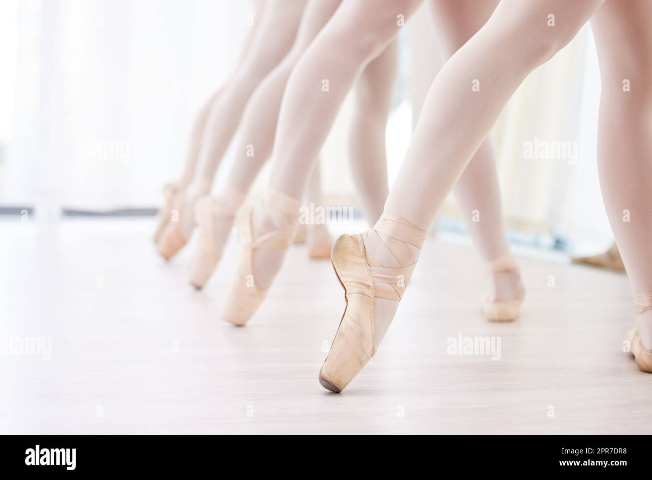 Eine Gruppe von Ballerina-Tänzern übt eine Routine in ihren spitzenschuhen. Stockfoto