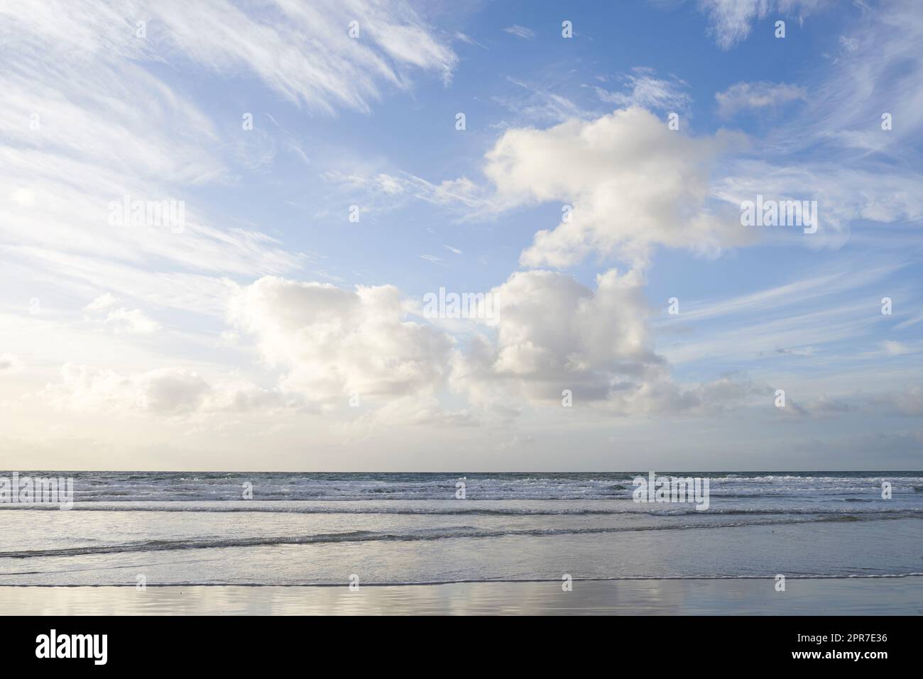 Kopieren Sie den Raum am Meer mit einem wolkigen blauen Himmel über dem Horizont. Ruhiges Ozeanwasser, das auf die Strandküste gespült wird. Küstenlandschaft für einen entspannenden Sommerurlaub in Torrey Pines, San Diego in Kalifornien Stockfoto